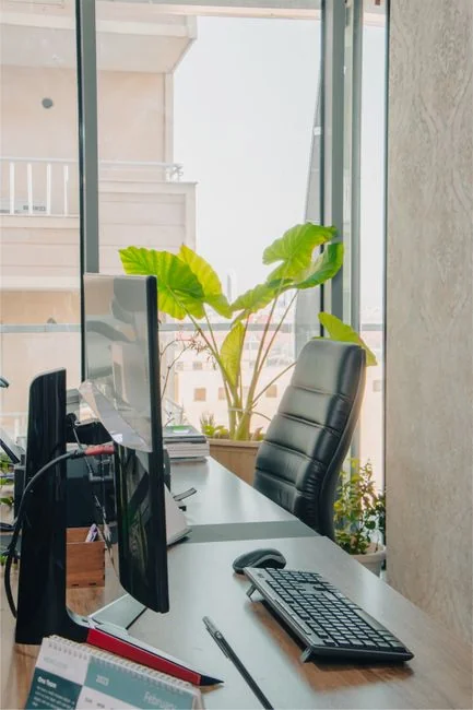 A lively workspace with a laptop, tablet, and TV illuminated by colorful lighting.